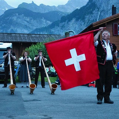 2023-07-18_Stechelberg am Folkloreabend des Tourismusbüro wird das Alphorntrio Silberhorn von einem Fahnenschwinger begleitet.